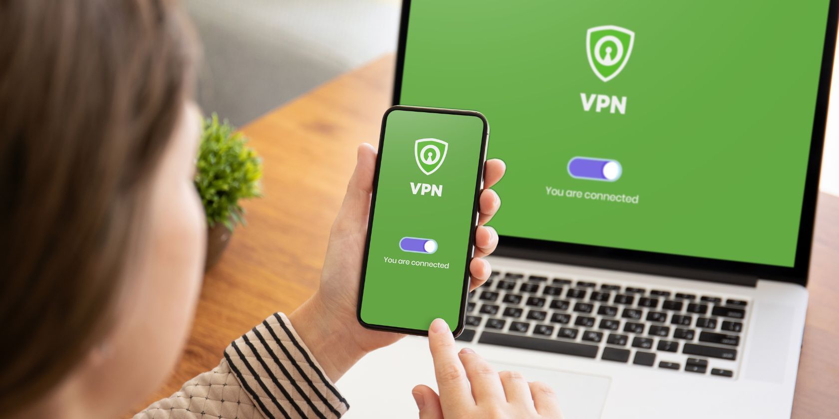 person activating vpn on phone and laptop