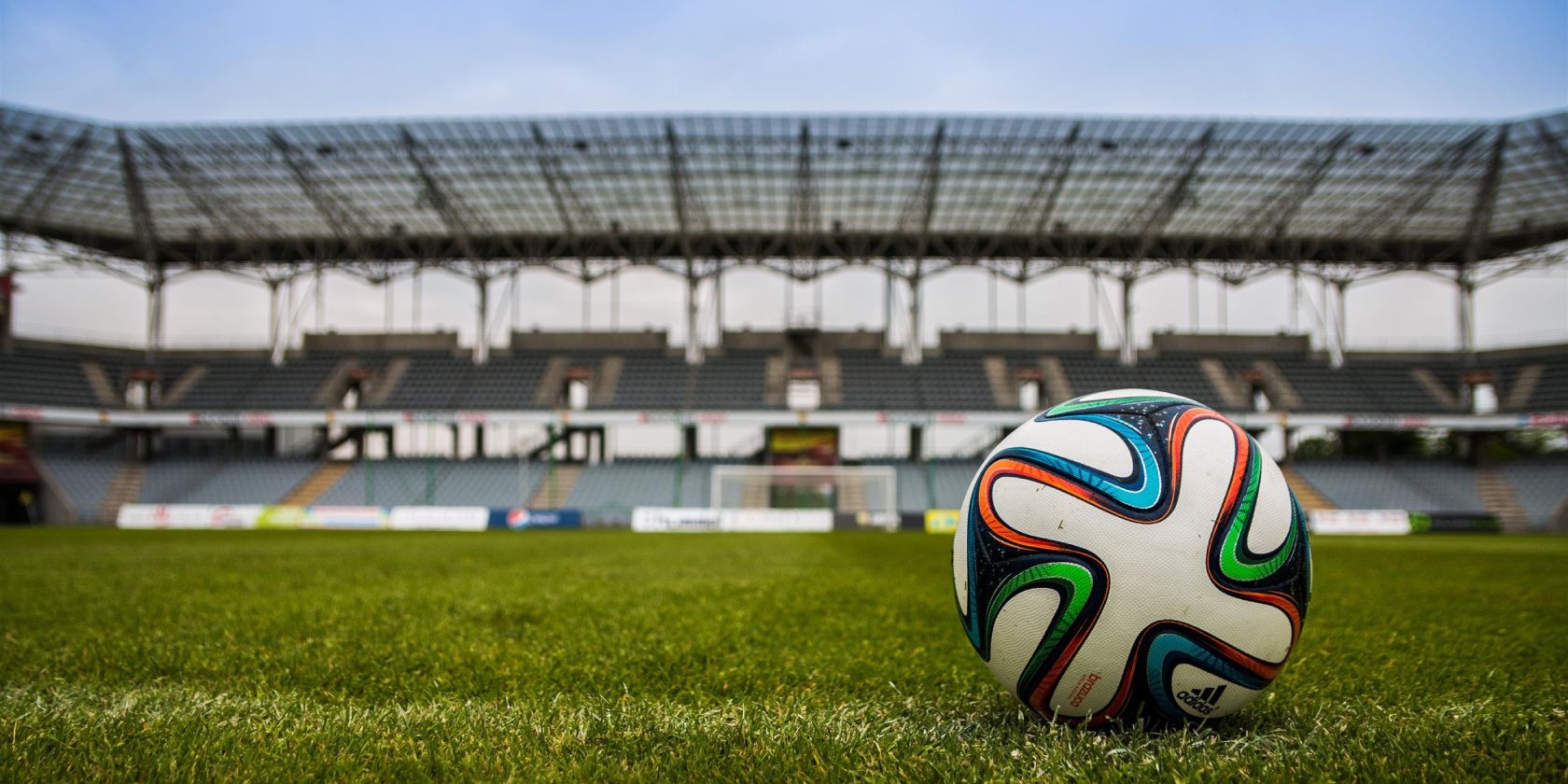 A soccer ball on the grass field of a stadium