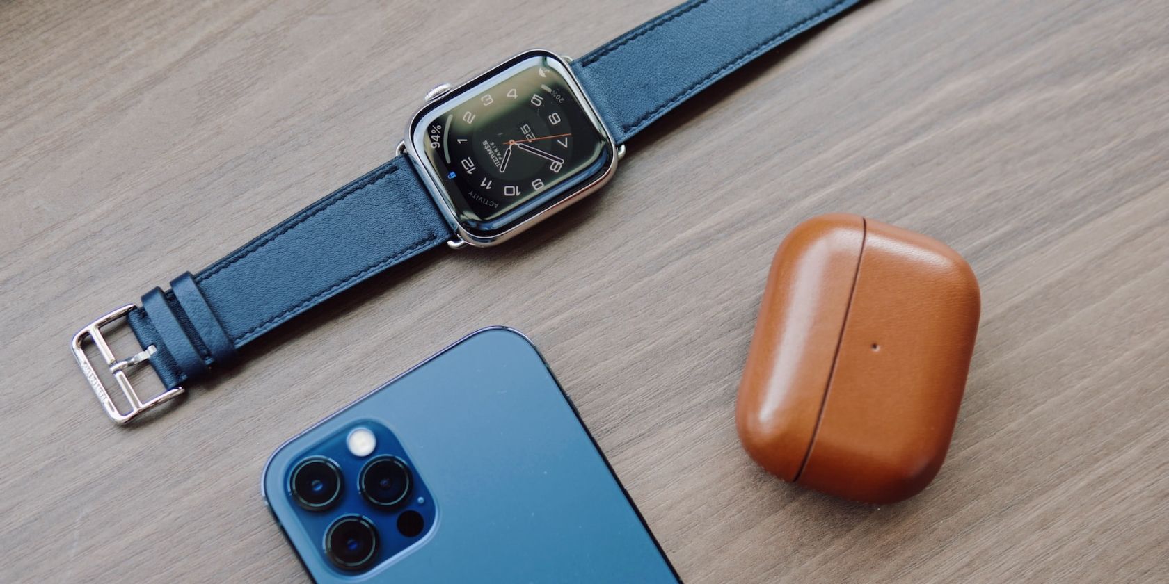 Apple Watch next to AirPods case and an iPhone