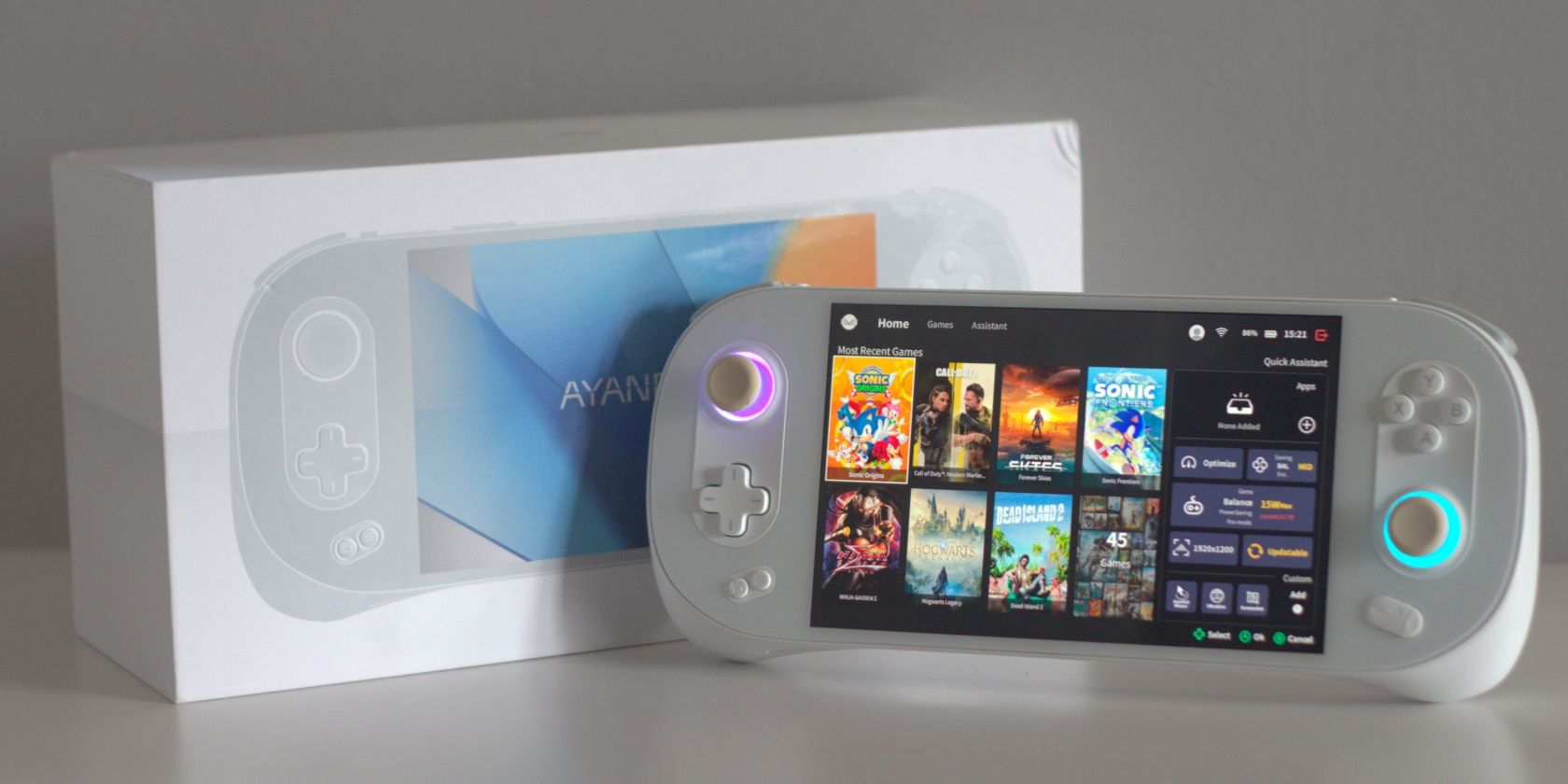 AYANEO 2S Product Photo showing a white handheld gaming PC sat in front of its own box on a white table with a white background