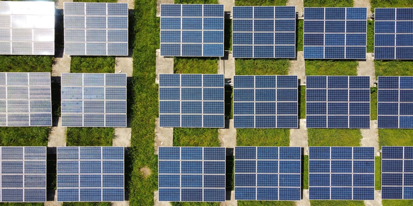 Three rows of solar panels, seen from a birds'-eye view.
