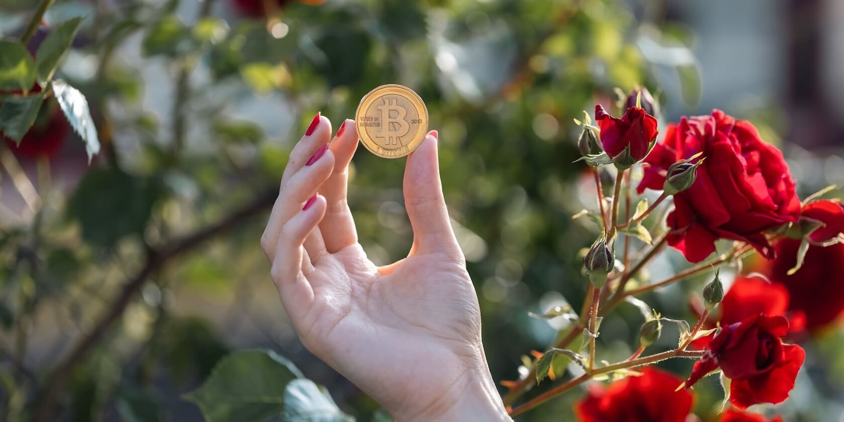 hand holding a bitcoin with a flowery background