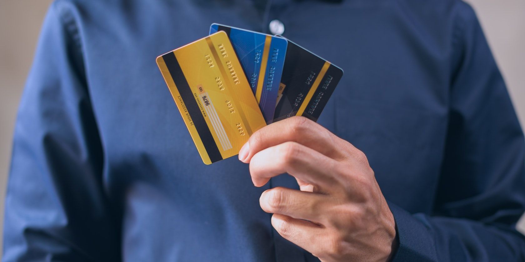 Cận cảnh bàn tay của một người đàn ông cầm một loạt thẻ ghi nợ