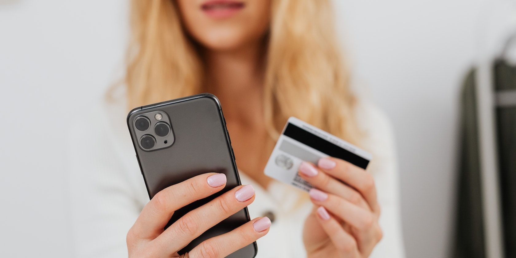 Close up shot of a woman holding an iPhone and a card
