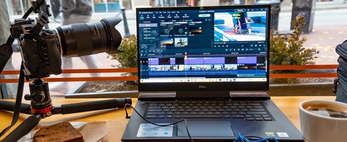 Área de trabalho com editor de vídeo ativado e câmera na mesa