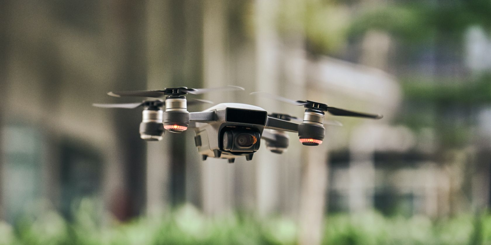 White quadcopter drone flying against a blurred background