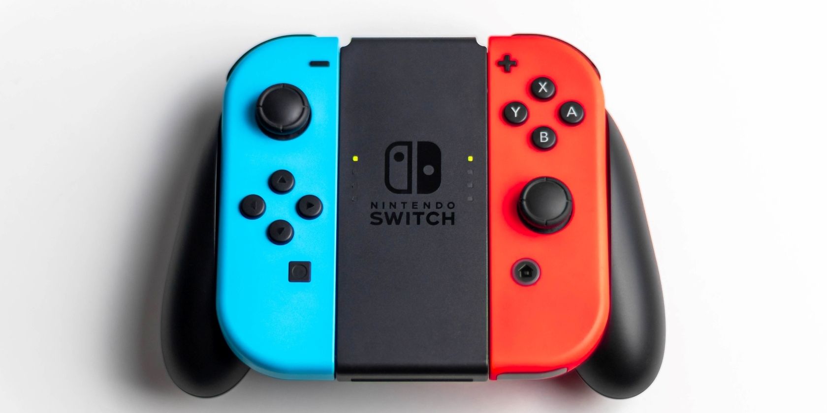 A photograph of two Nintendo Switch Joy Con attached to a controller adapter 