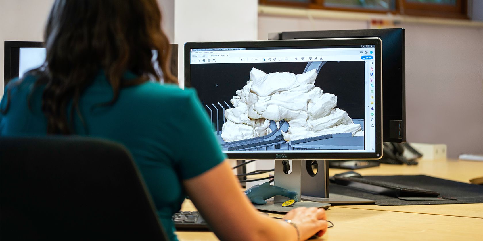 A lady working on a 3D model on her computer