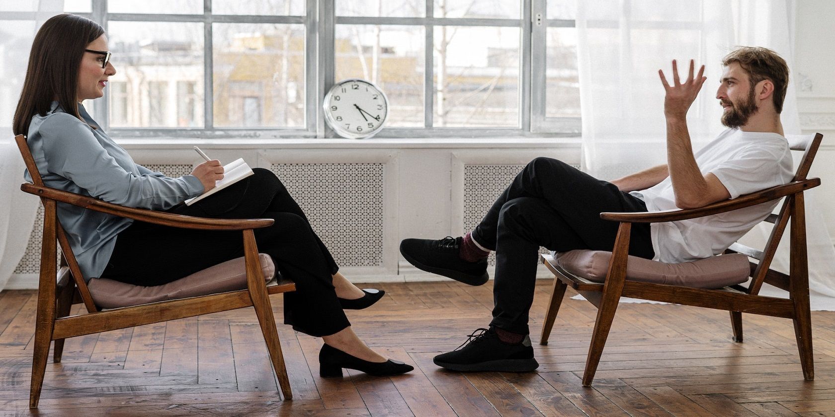 Image of a man and woman having a conversation sitting on chairs