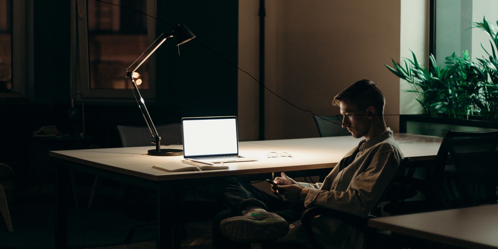Image of a man at his desk at evening time