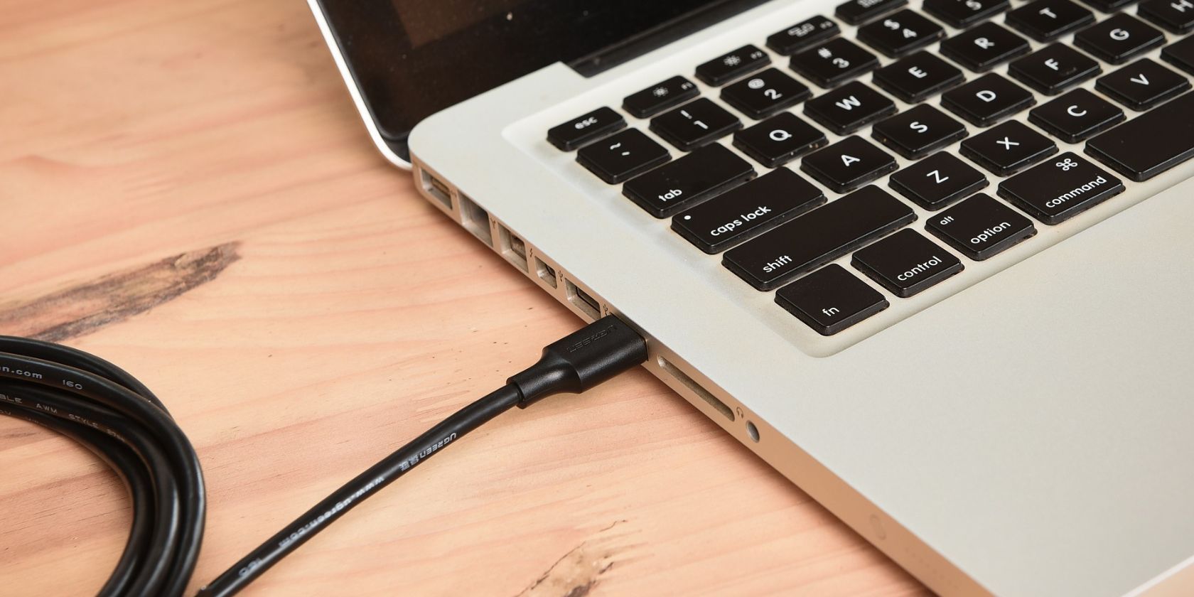 USB cable plugged into a laptop's USB port
