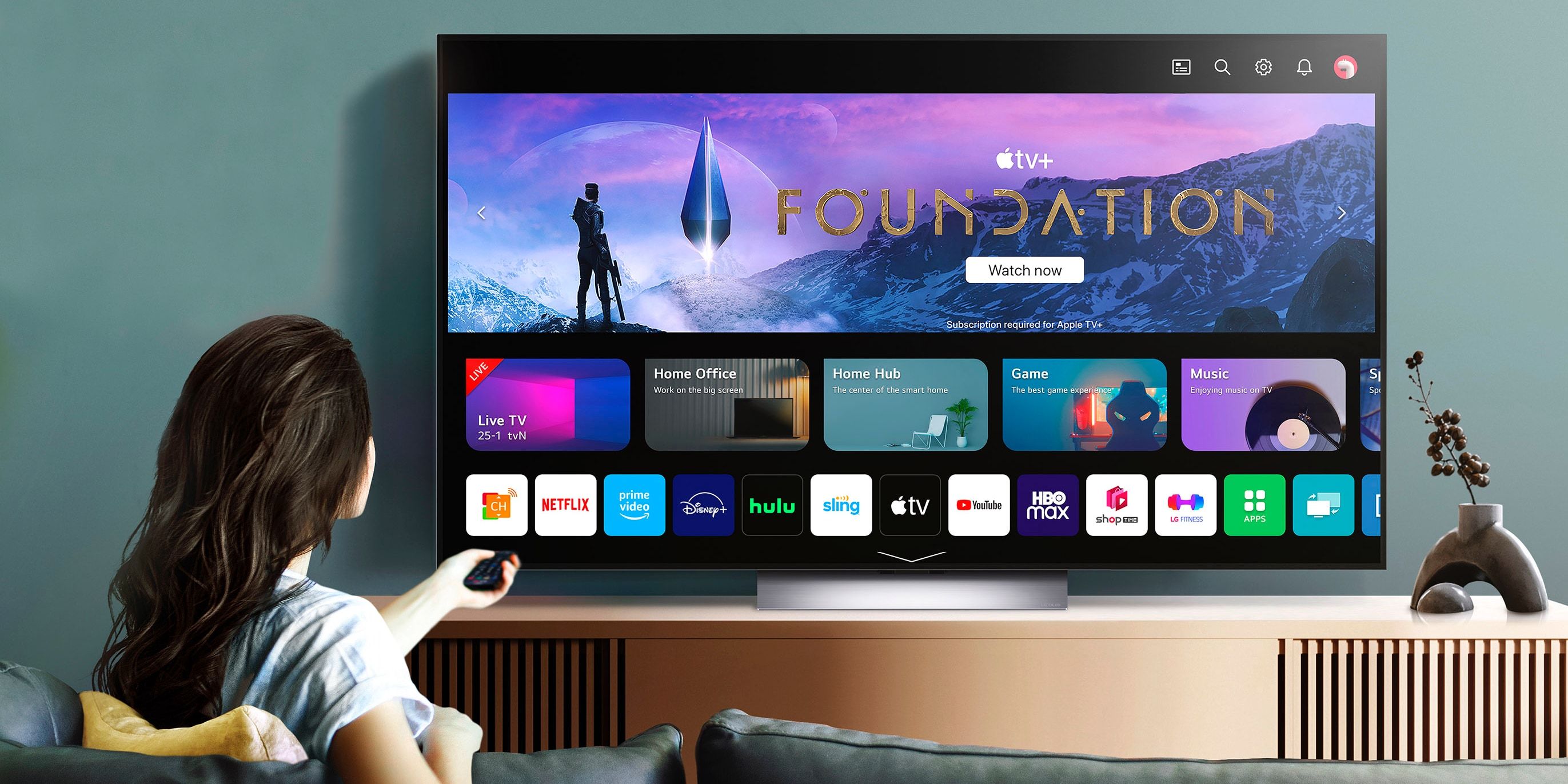 Woman on a couch and watching the Apple TV+ show Foundation on LG's OLED TV