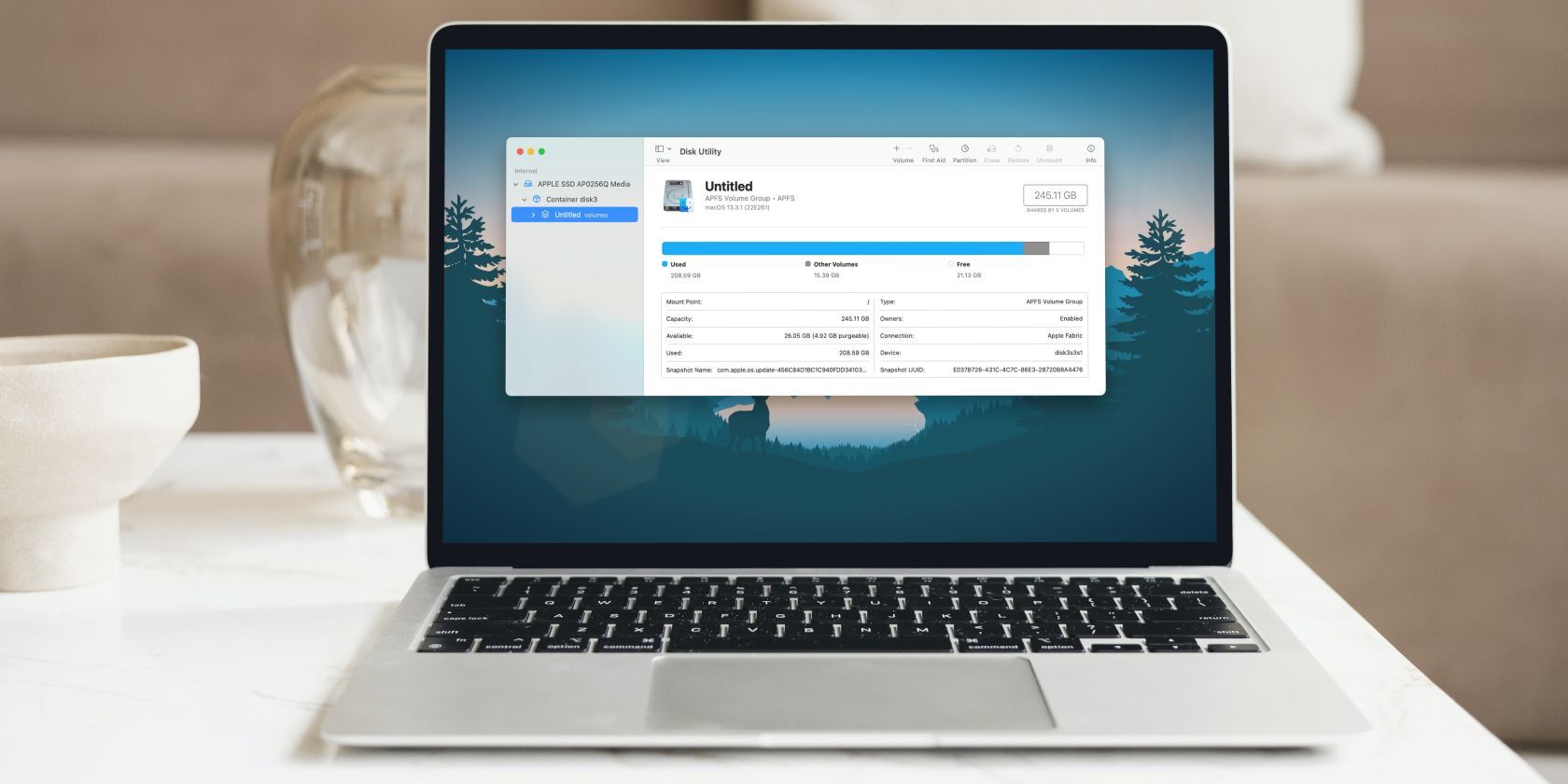 MacBook Air on a white desk with macOS Disk Utility on the screen