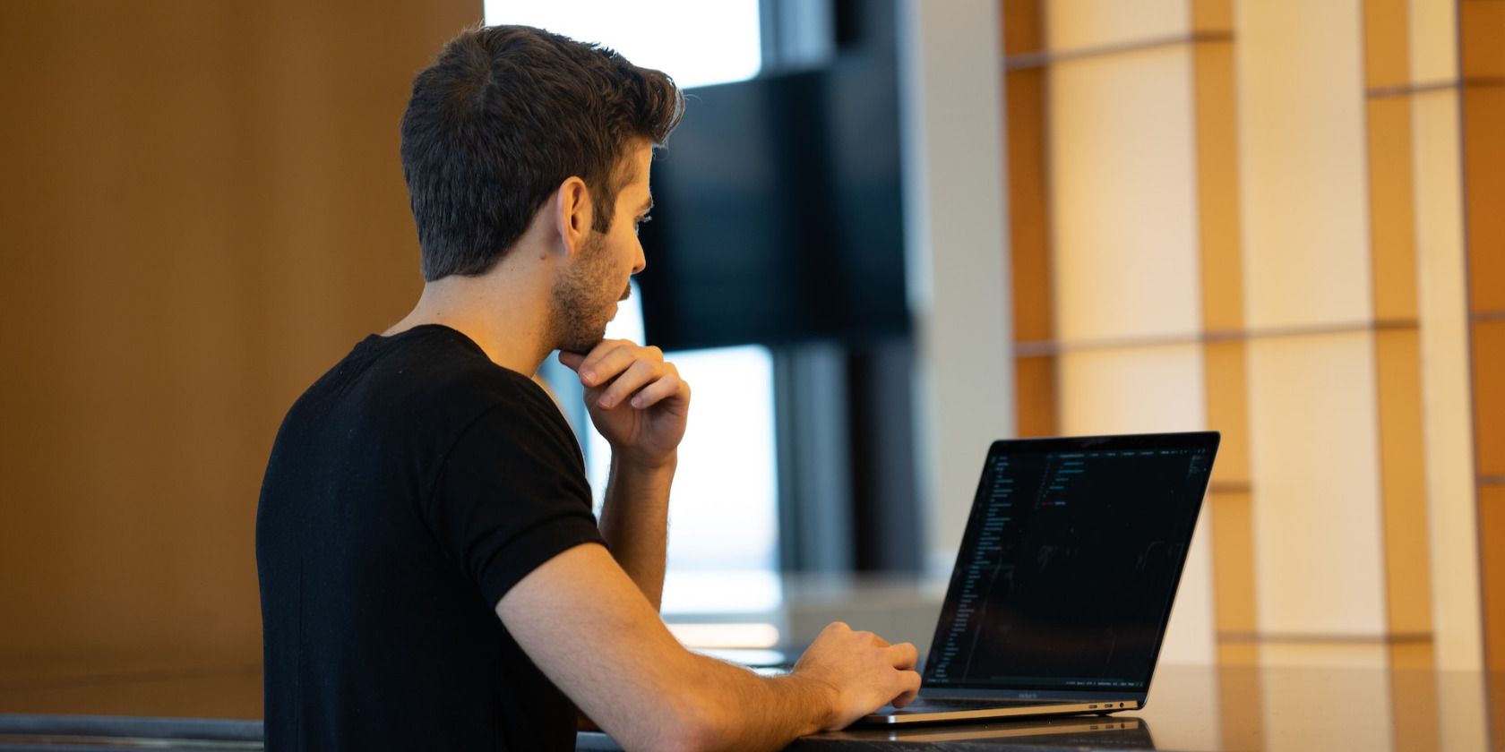 Man in black shirt using laptop