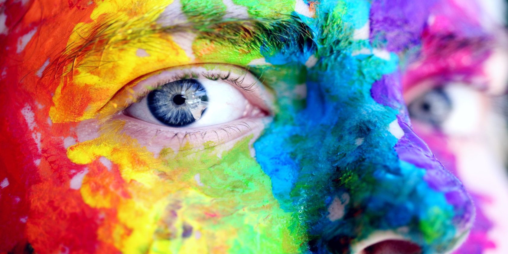 A close-up of someone's face painted in many different colors.