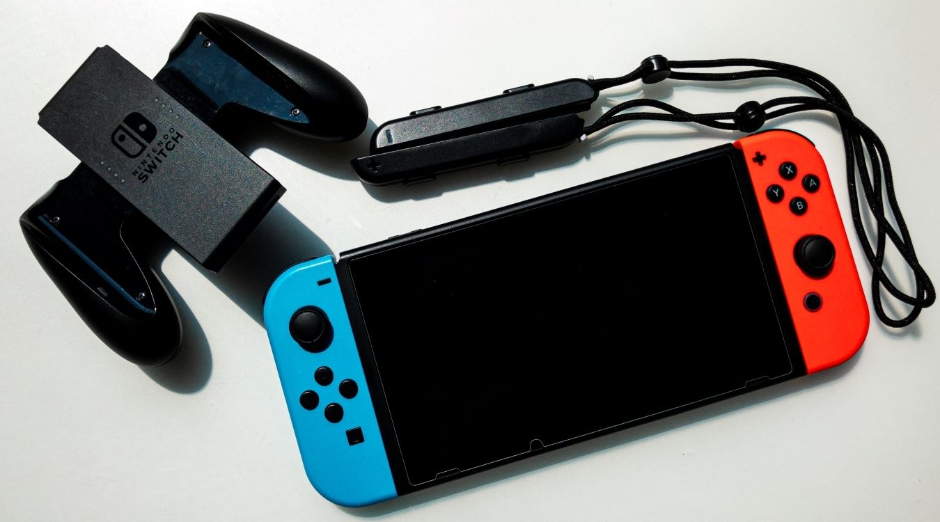 A photograph of a Nintendo Switch console next to Switch accessories 