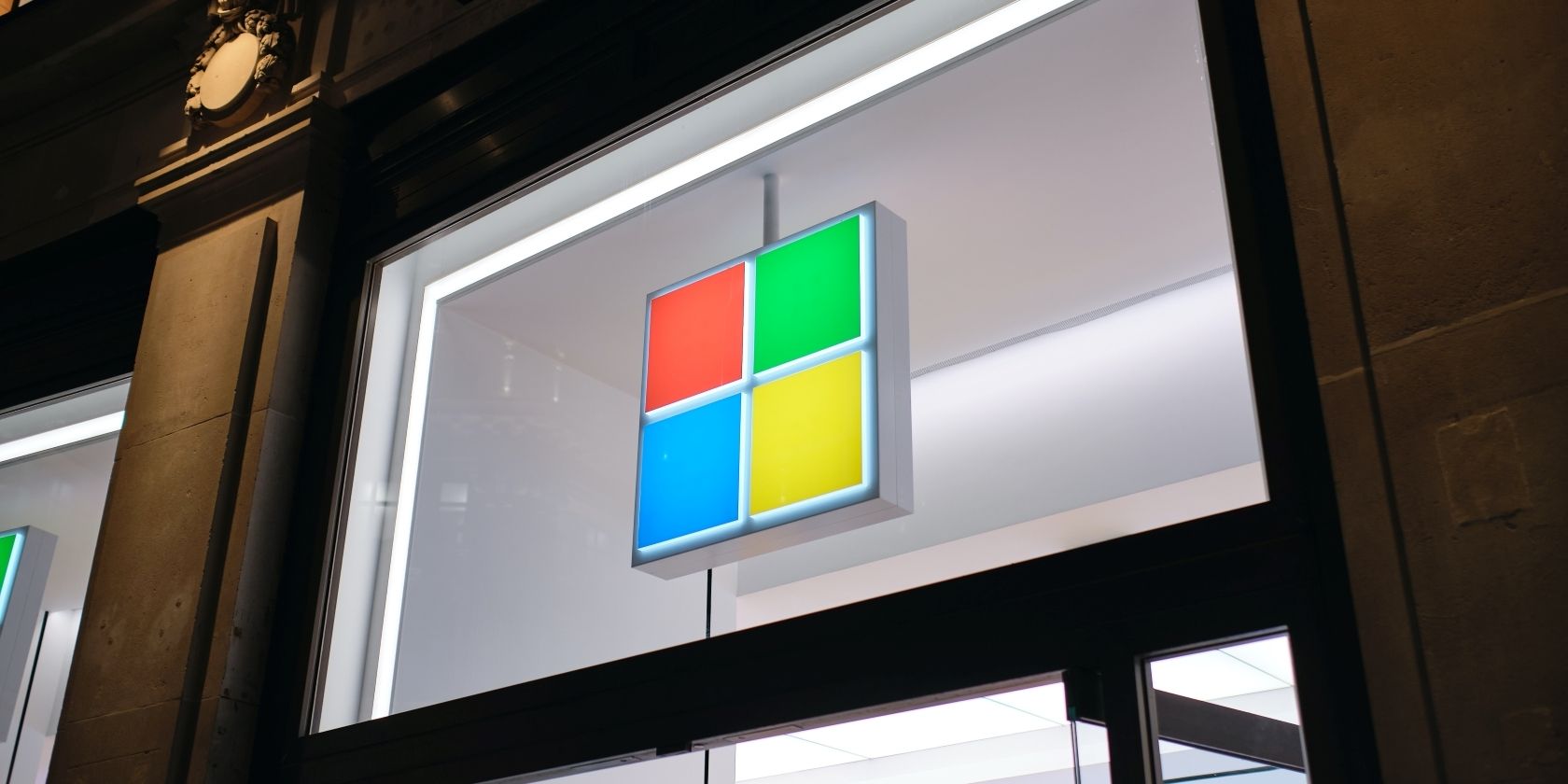 A photograph of the Microsoft logo displayed on the window of a building
