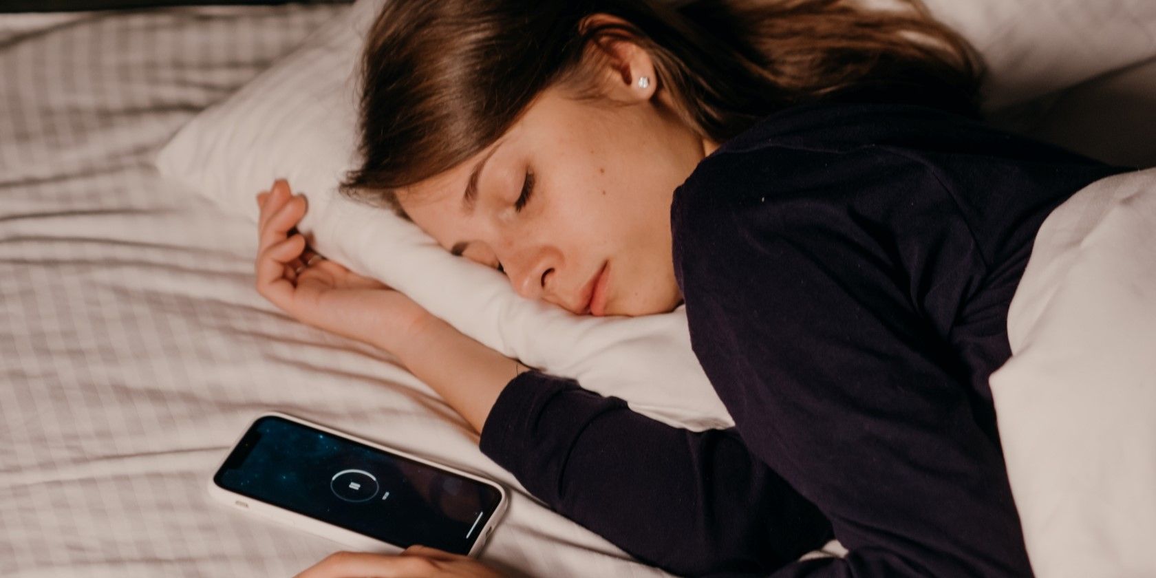 woman sleeping with her phone nearby