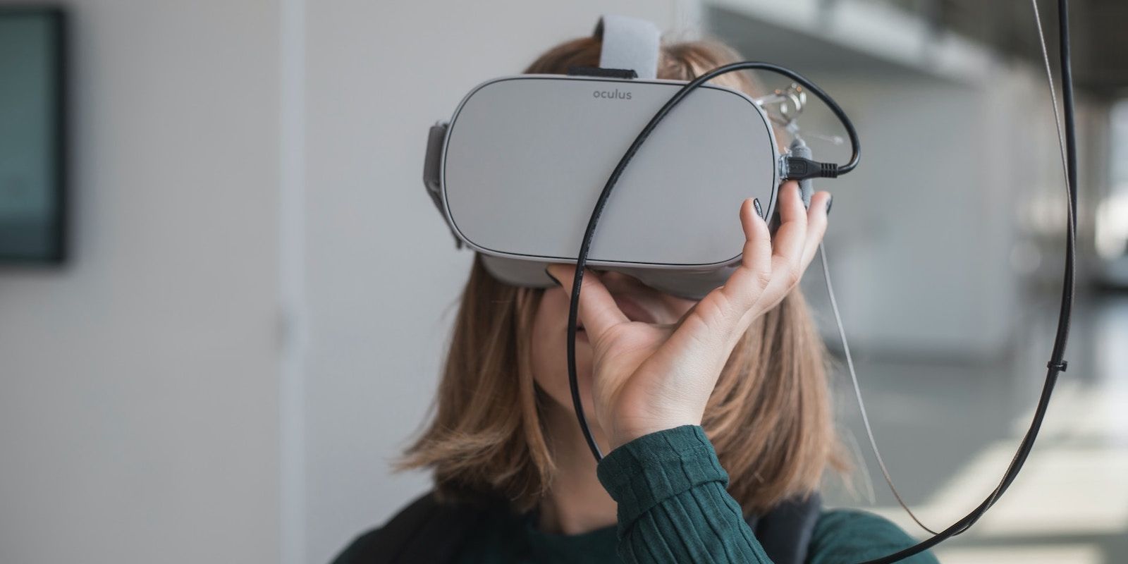 زنی با هدست سبز رنگ Oculus هنگام استفاده از آن