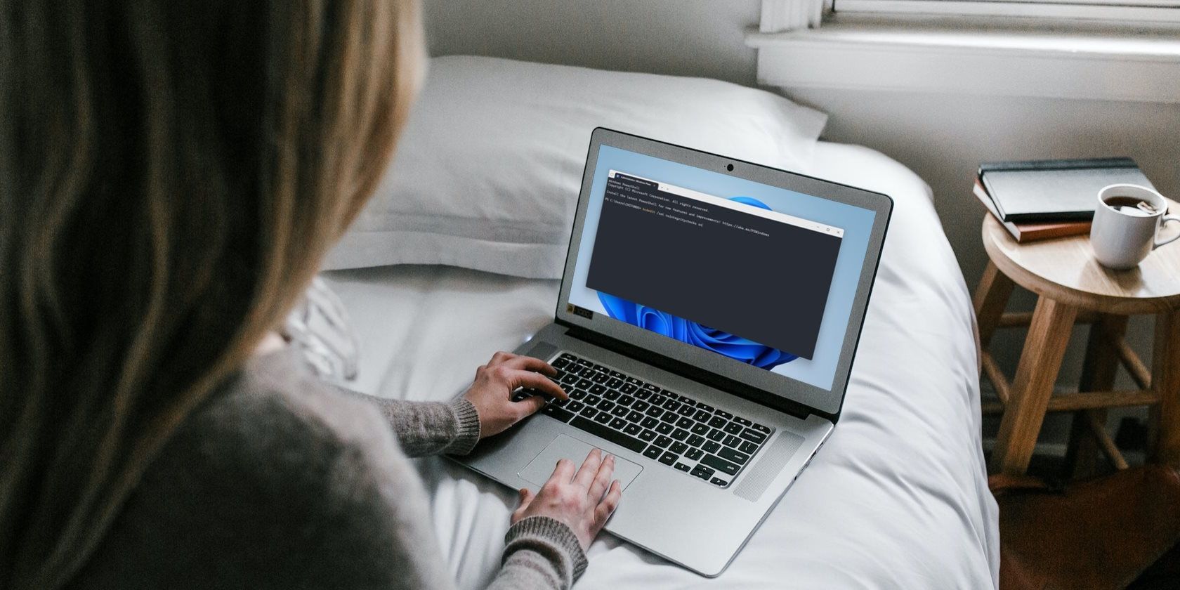 a woman using a windows laptop on a bed