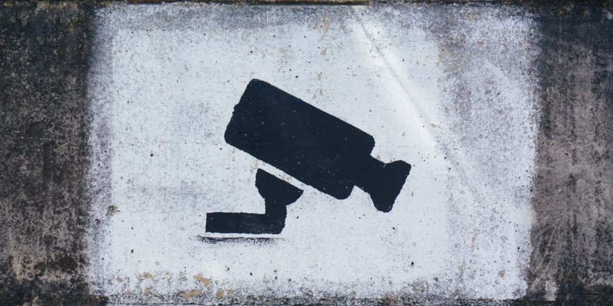 Uma pintura de uma câmera CCTV preta sobre um fundo branco