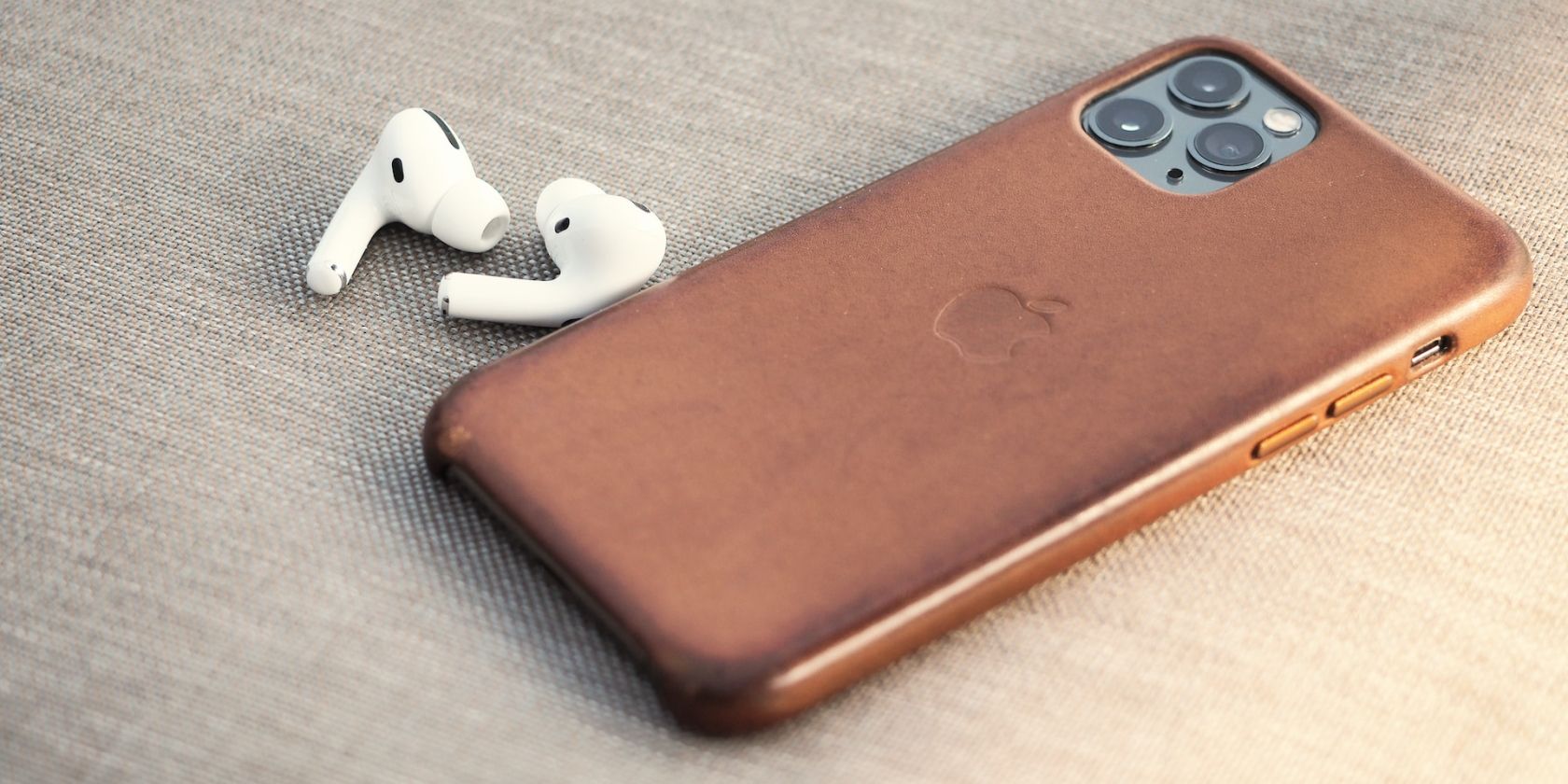 AirPods Pro next to an iPhone in a leather case