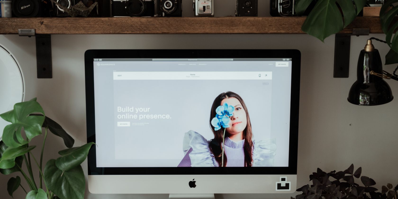 An iMac displaying the Squarespace website builder on screen