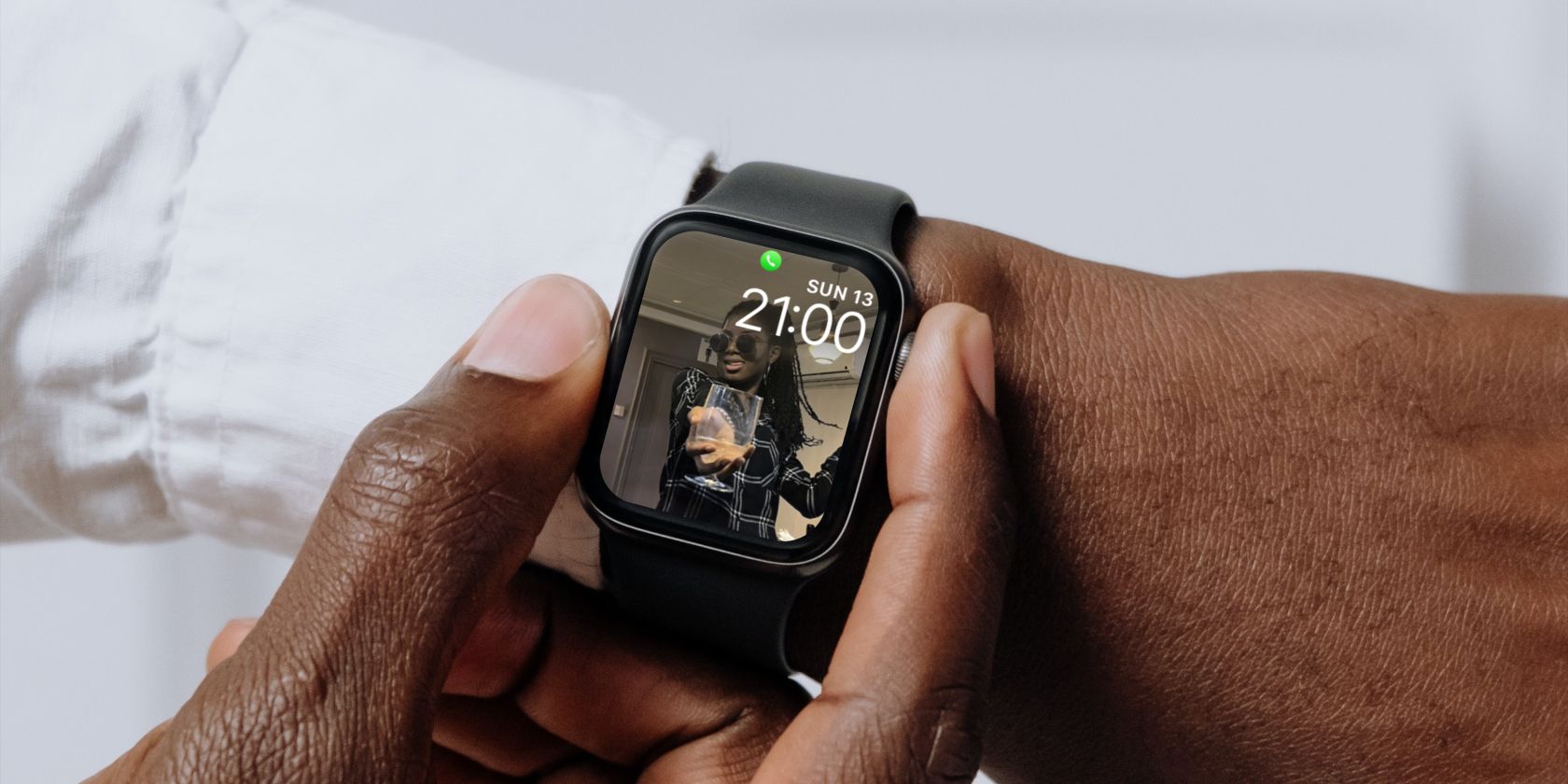 Apple Watch on a man's wrist with the photo of a woman holding a glass
