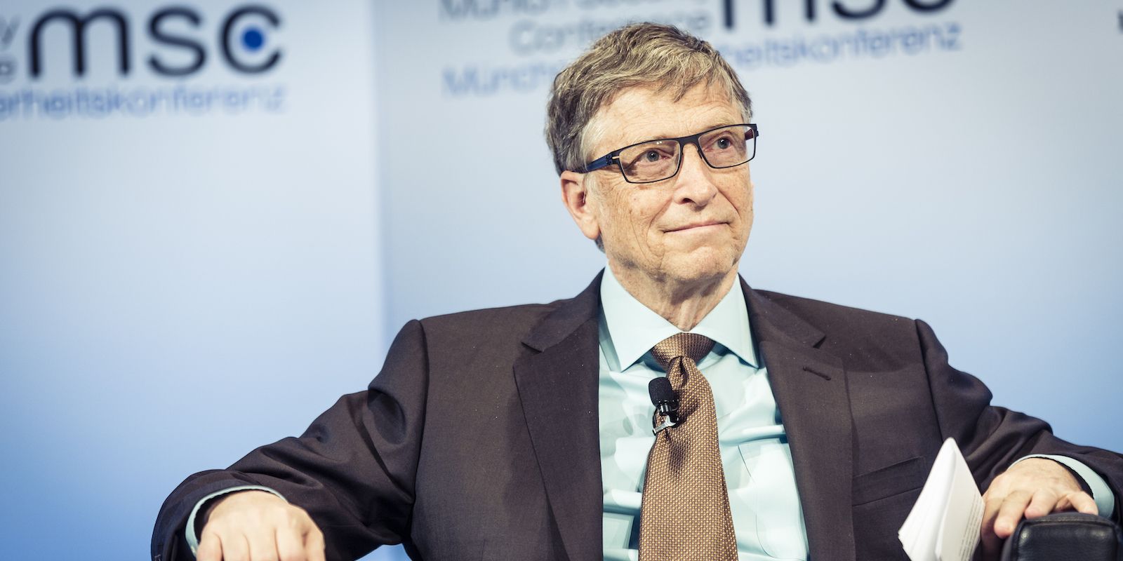 Bill Gates Speaking at Tech Event While Seated and Smiling