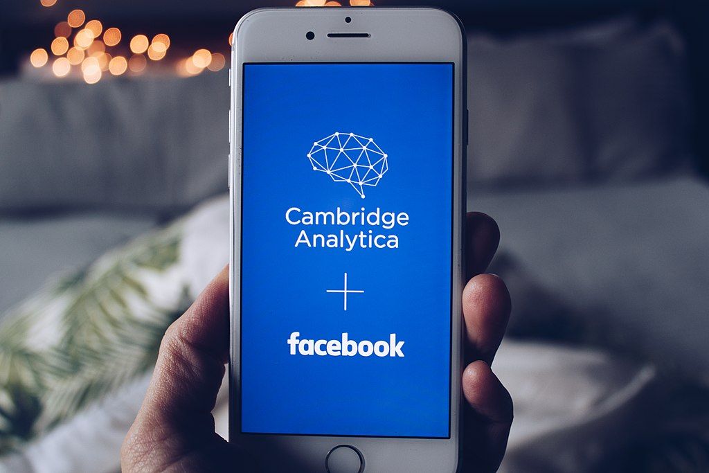 A phone screenshot displaying Cambridge Analytica and Facebook logos