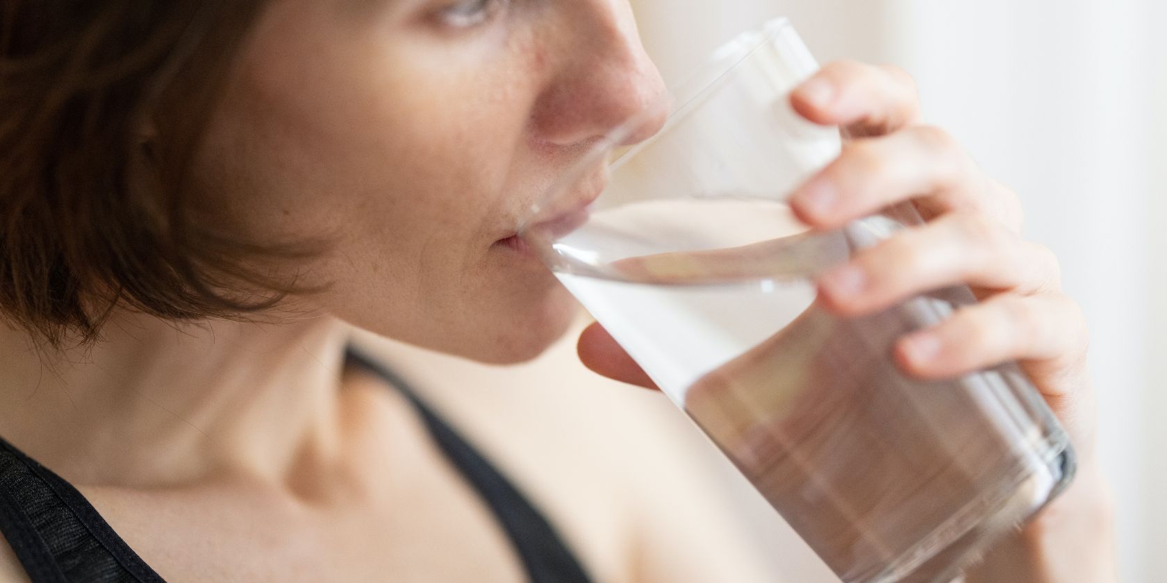 person drinking a glass of water
