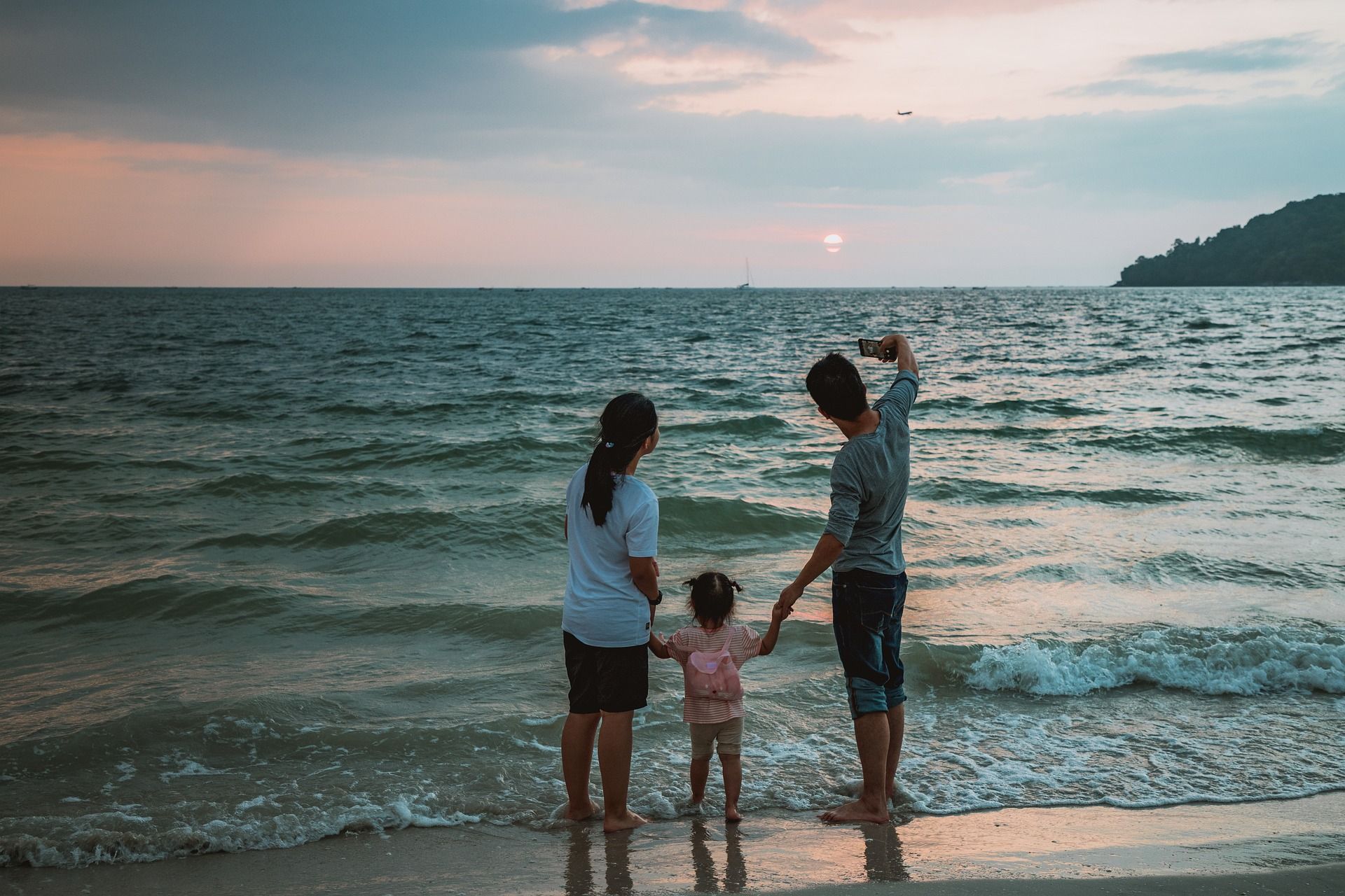 Famille observant l'horizon à la plage