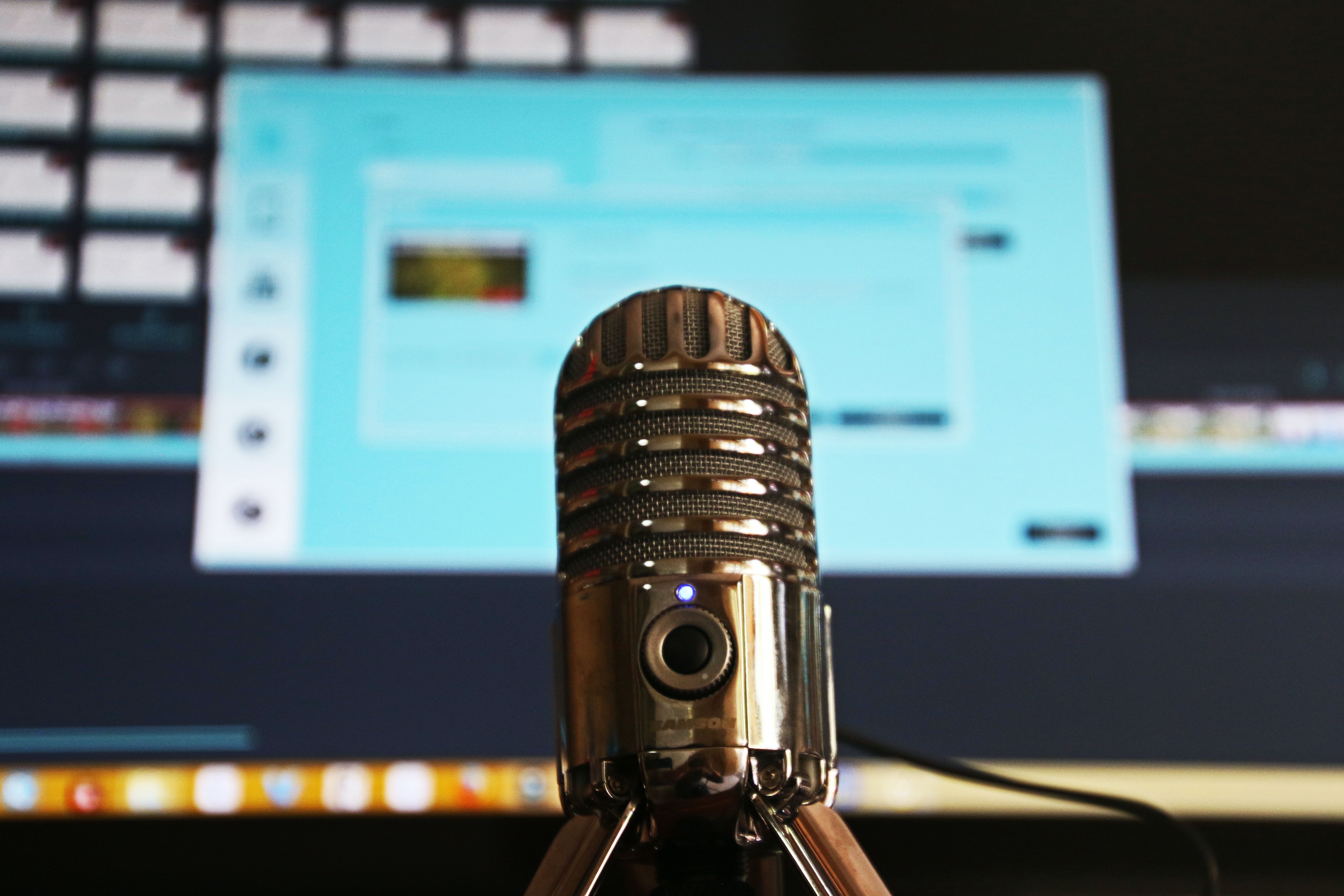 Microphone sur pied avec un écran d'ordinateur derrière lui