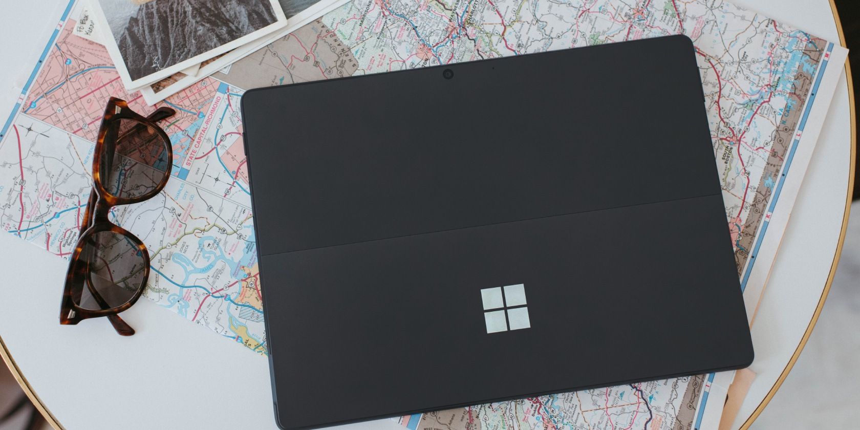 A windows laptop on a table with a map