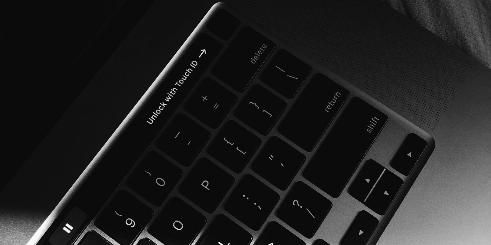 MacBook keyboard with the Touch Bar saying unlock with Touch ID