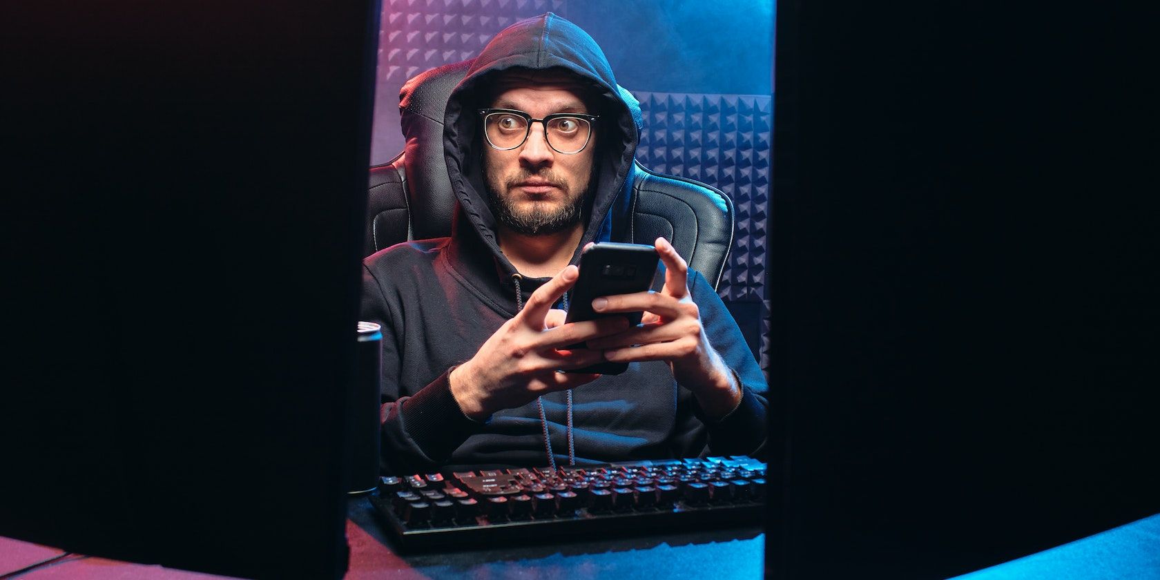 Man in black hoodie stares at laptop screen