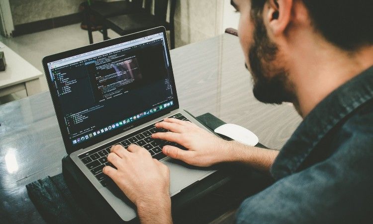 un homme qui écrit du code sur son ordinateur portable