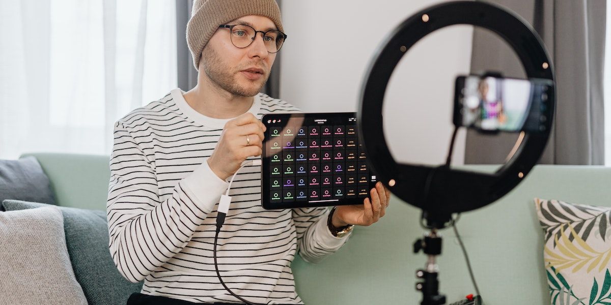 um homem revisando um tablet enquanto se grava diante da câmera