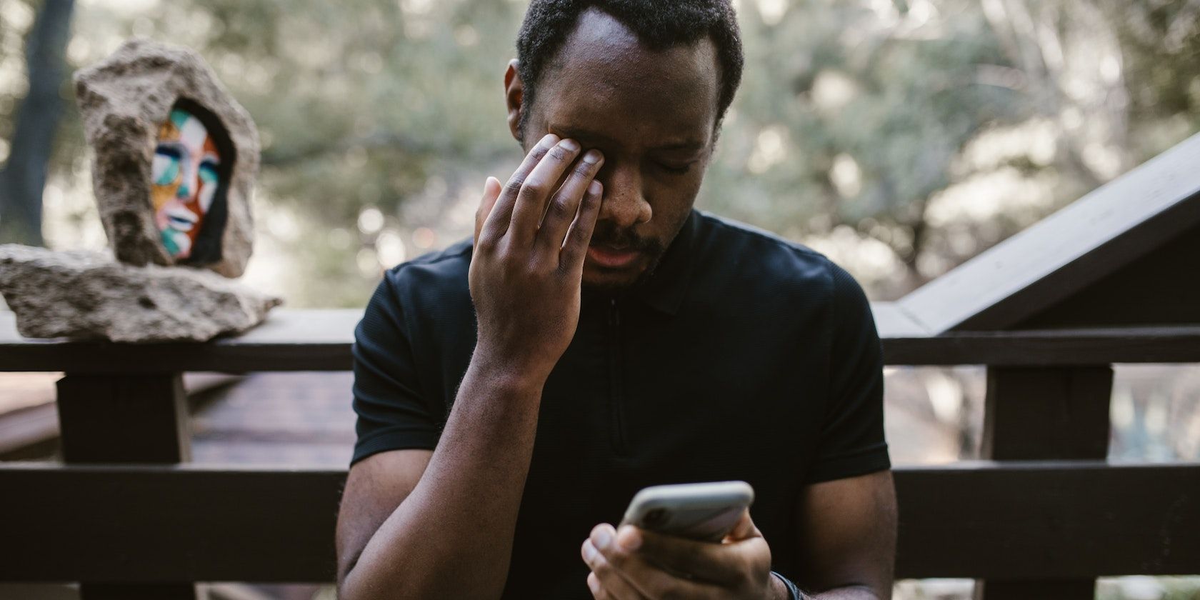 Homme assis sur un banc, téléphone à la main