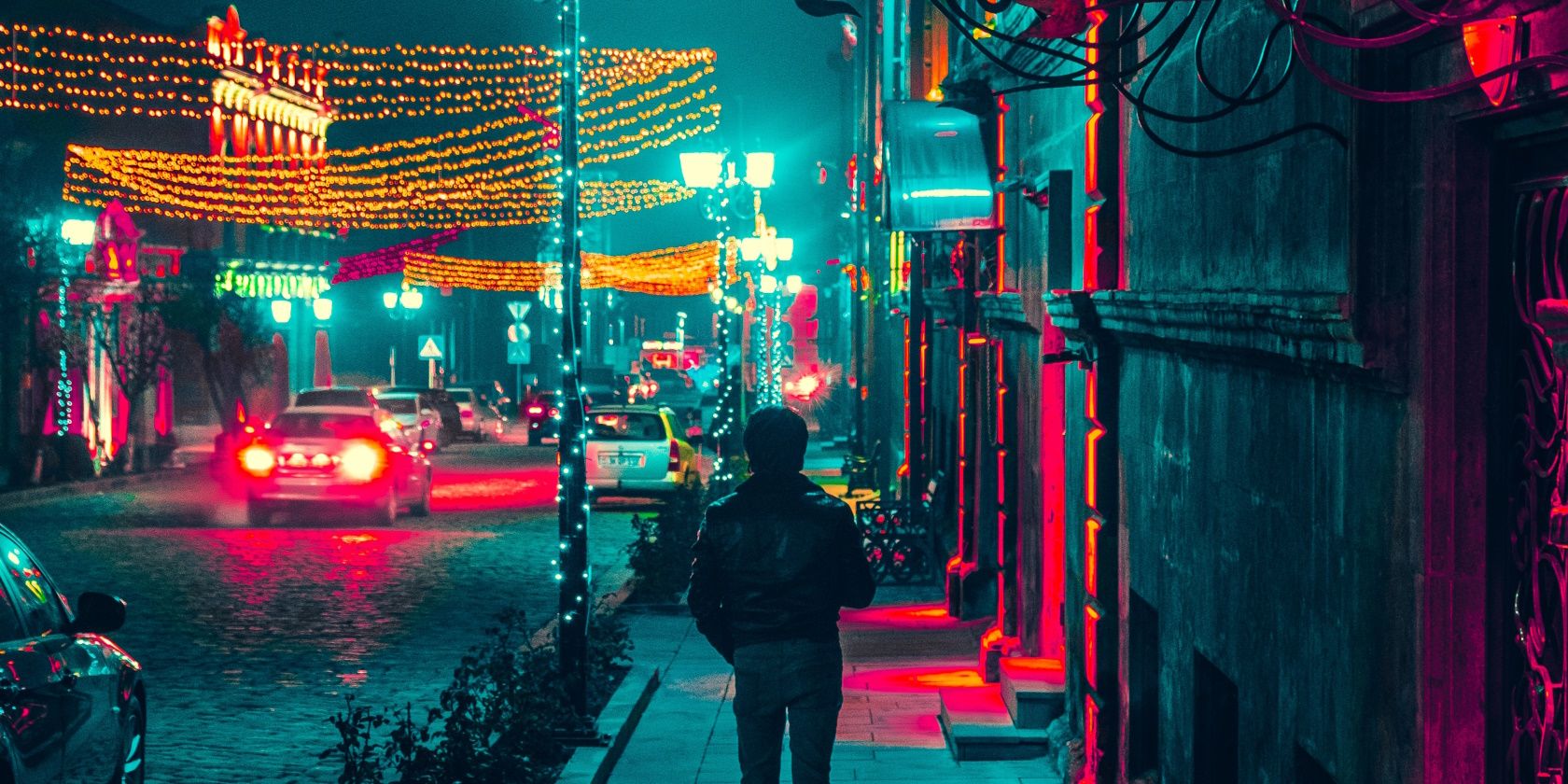 Man walking along a sidewalk during nighttime