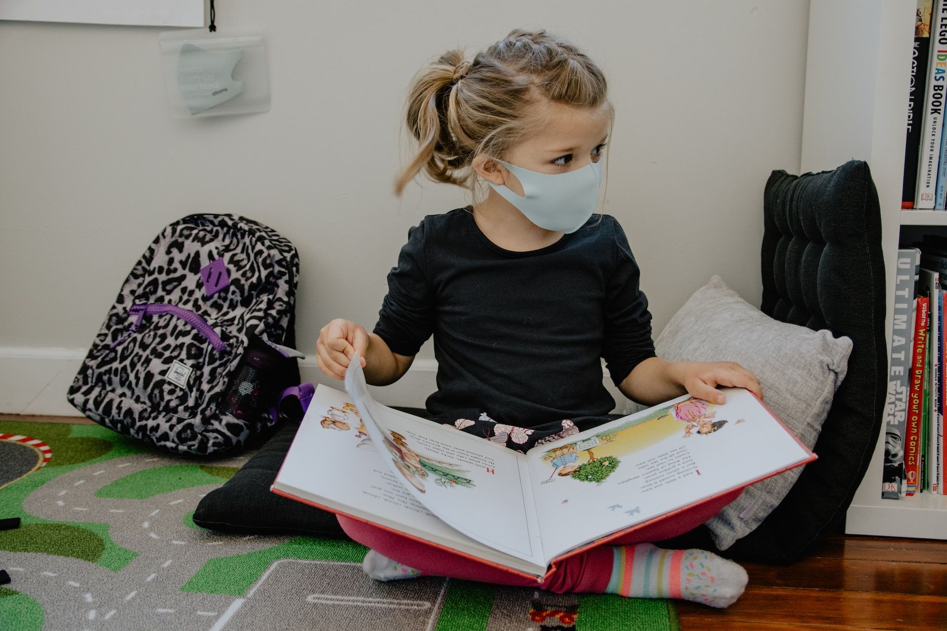 Fille masquée lisant un livre