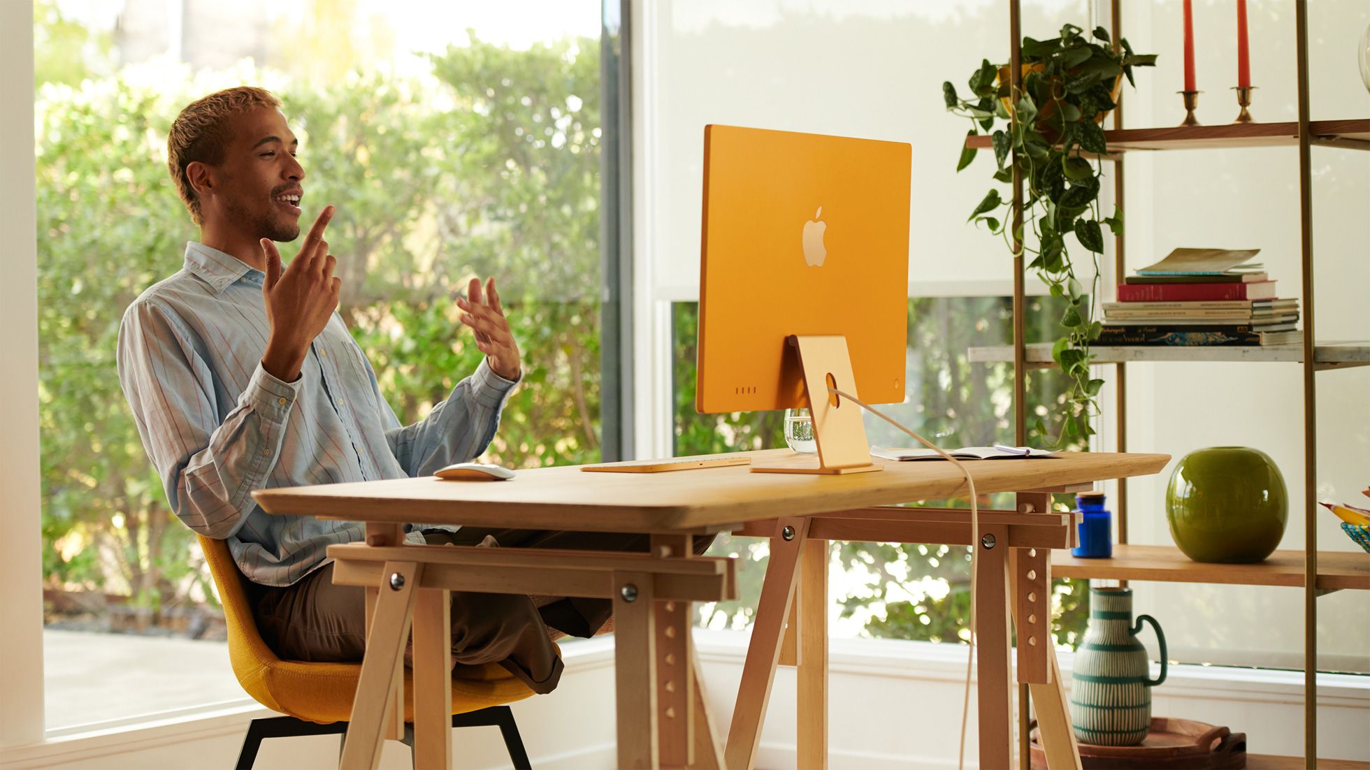 person sitting on a chair in front of an iMac