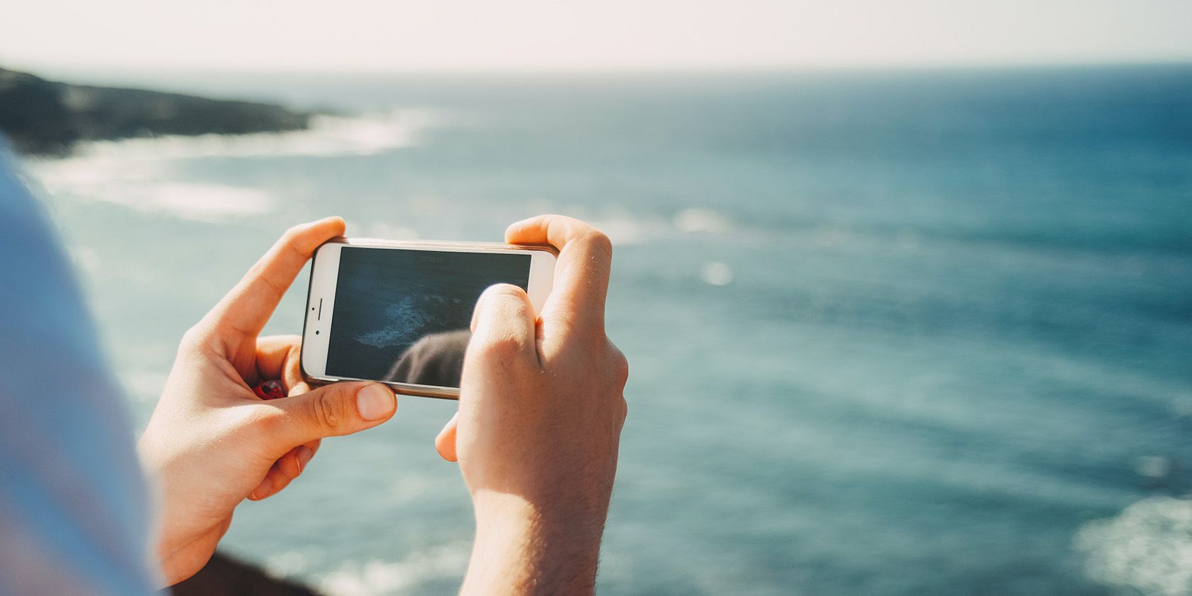 Personne prenant une photo de l'océan avec un smartphone