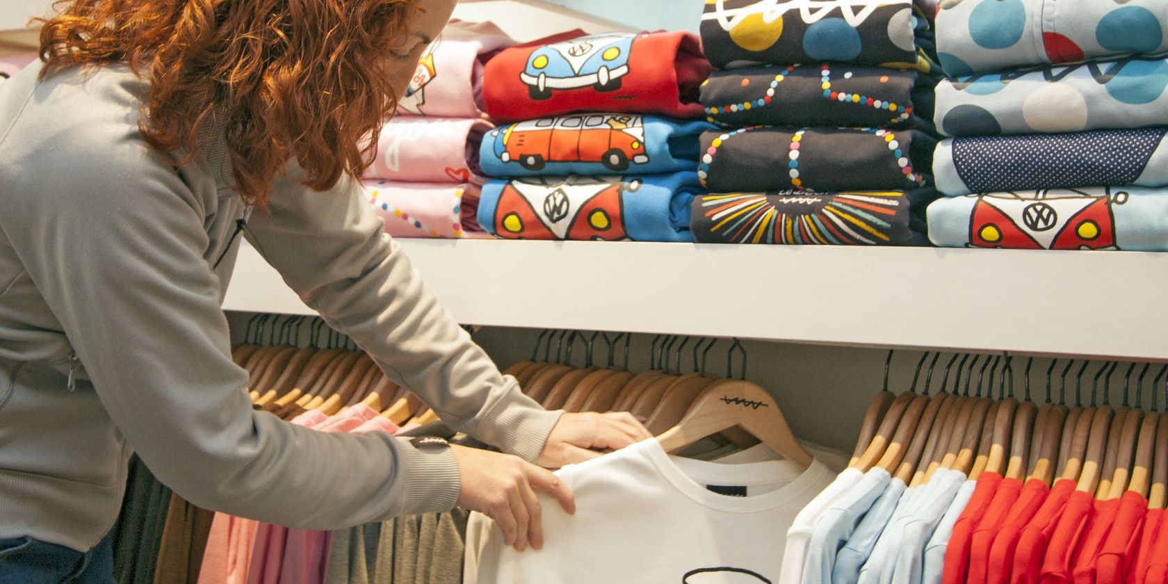 A Woman Choosing and Buying T-Shirts at a Store