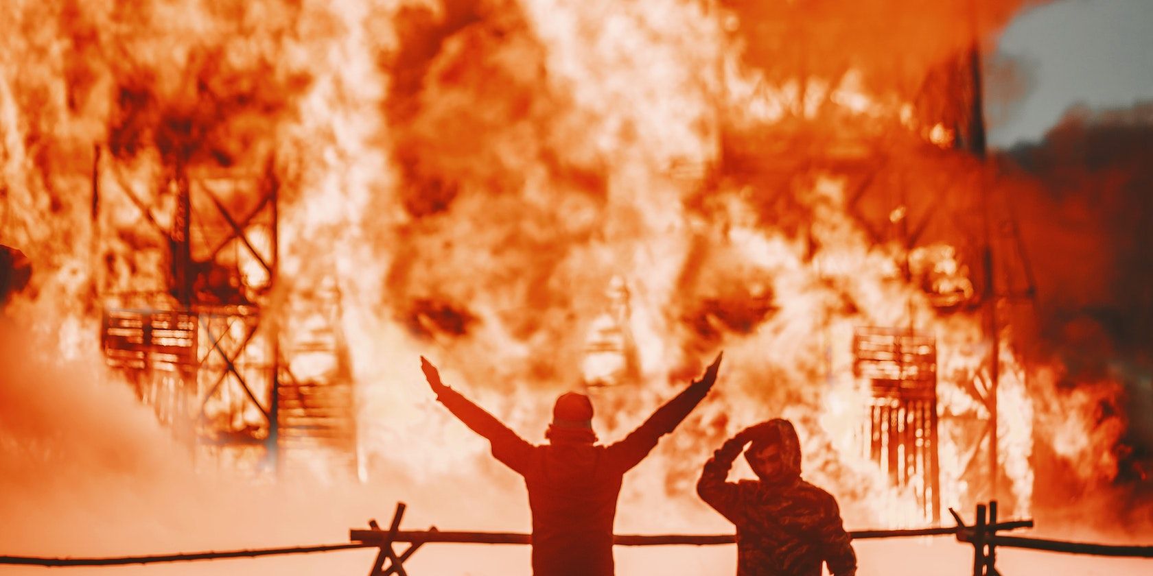 deux hommes devant un immeuble en feu
