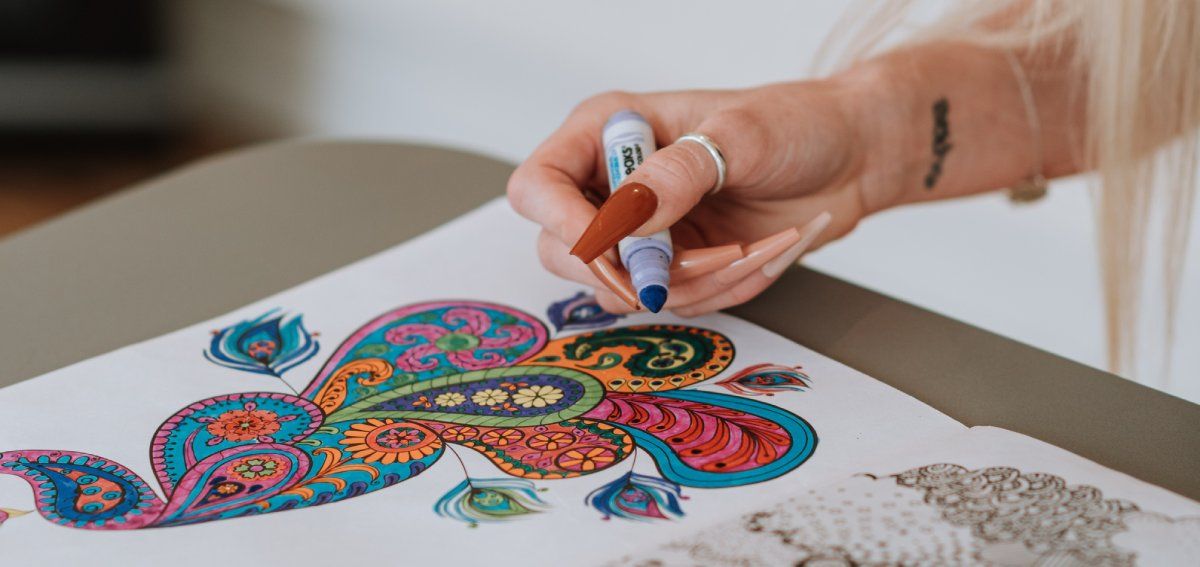 Mulher colorindo em livro para colorir com marcadores