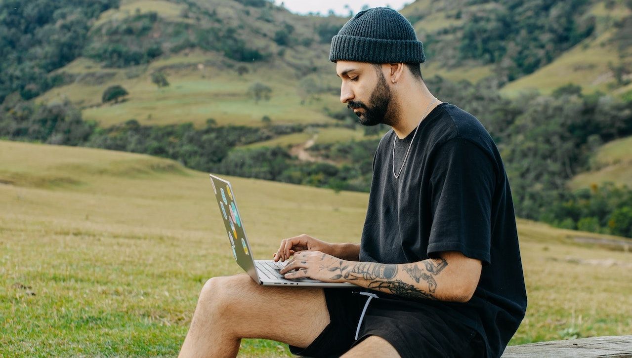 Homem trabalhando em um computador ao ar livre