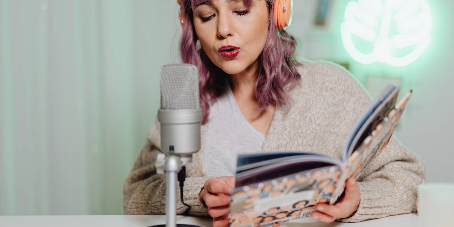 A woman talking into a microphone recording an audiobook