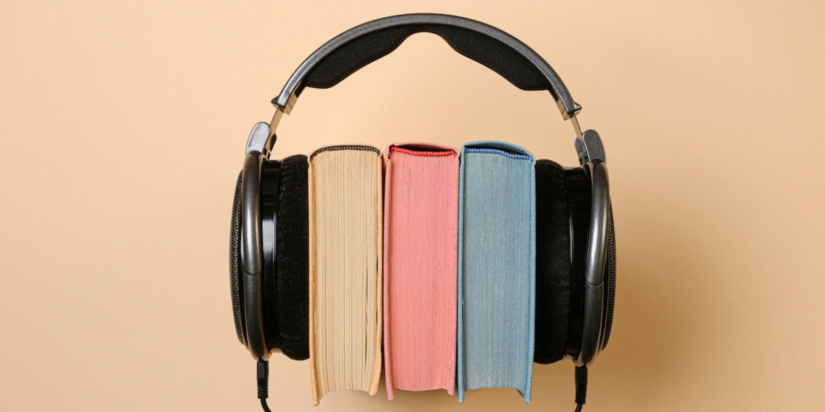 Black headphones with three books in between