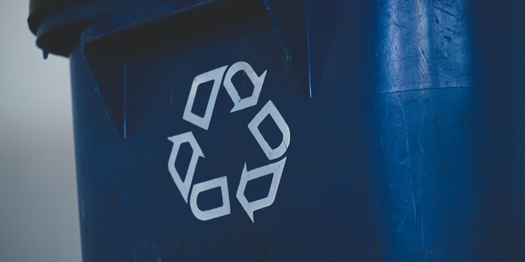 A Blue Recycle Bin With a White Logo for Recycling